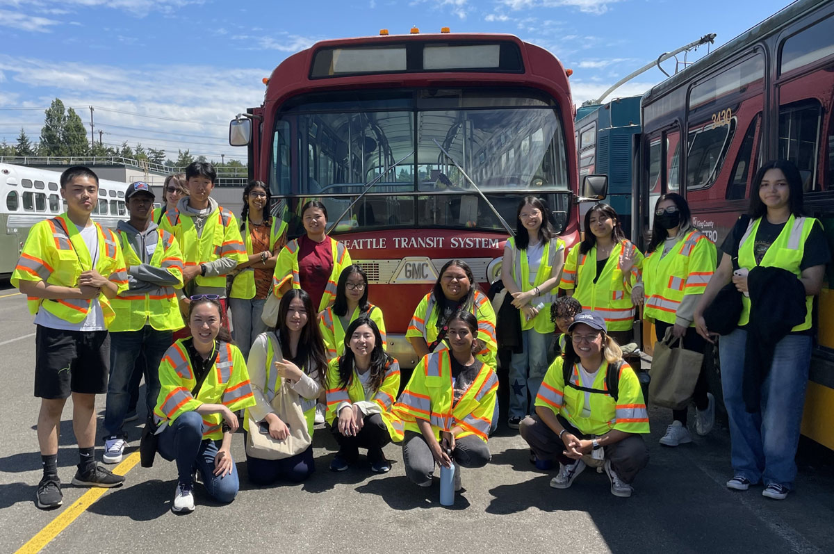 A group of youth interns in front of a vintage Metro bus